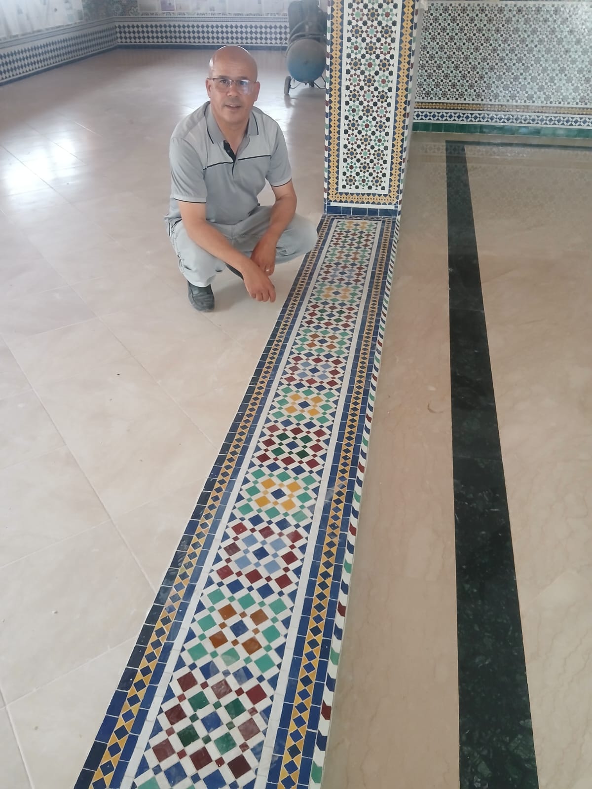 DTAT Maâlem inspecting a freshly laid zellige beldi border